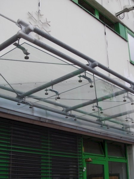 Zasklívání exteriérů - skleněná stříška nad vchodem obchodu