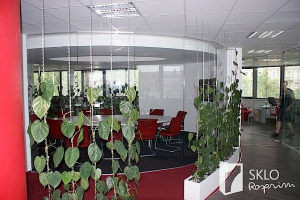 Zakulacená skleněné stěna konferenční místnosti a skleněné příčky mezi kancelářemi