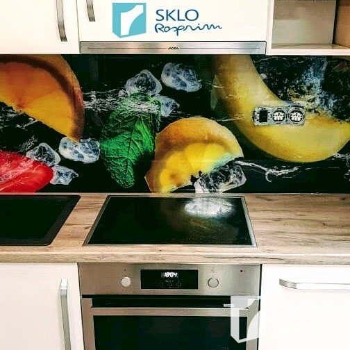 Detail na barevný skleněný obklad za kuchyňskou linkou s motivem ovoce